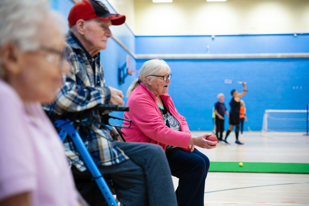 Senioren spielen ein Spiel in einer Turnhalle.